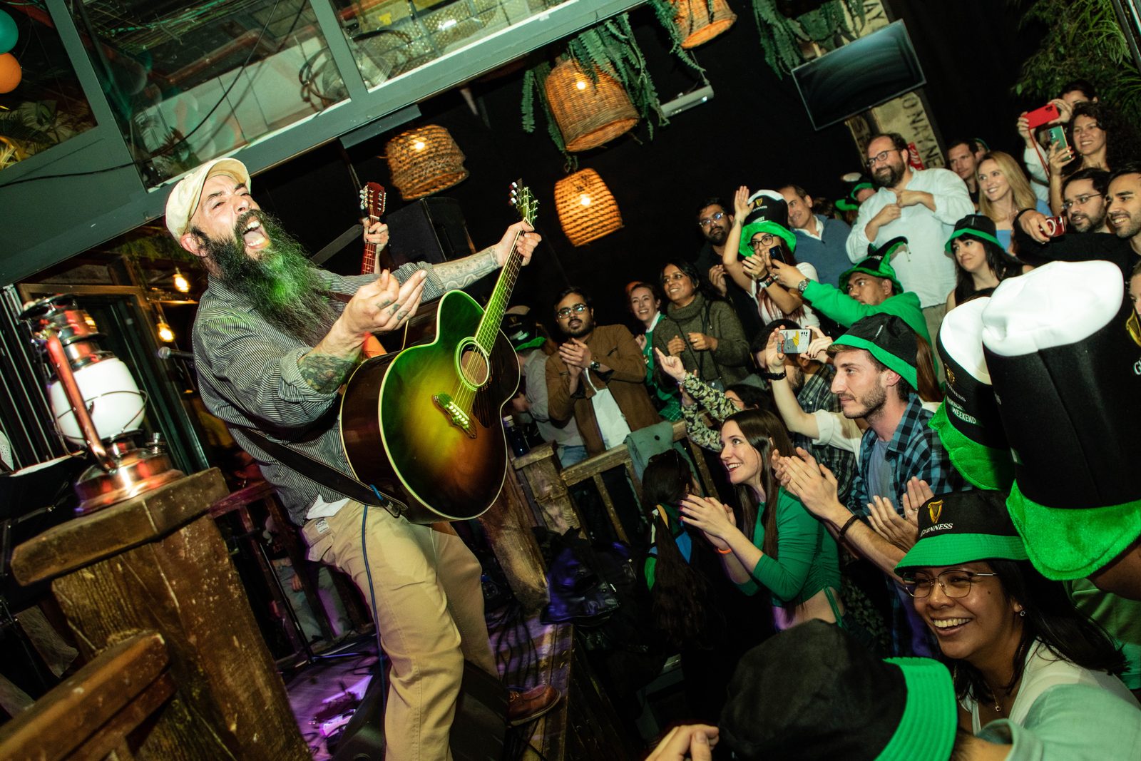 Guitarrista de The Lighthouse Keepers cantando frente al público en un pub irlandés